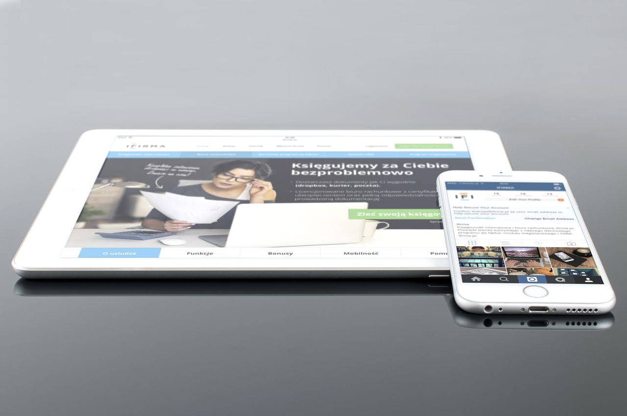 team-01 Modern tablet and smartphone displaying web content on a reflective surface, highlighting technology and connectivity.
